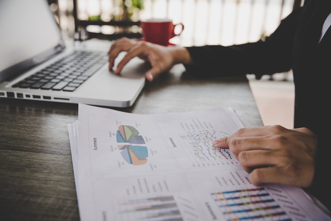 Feasibility study report and financial projection charts on a professional desk representing business feasibility study services for Caribbean entrepreneurs